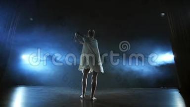 现代芭蕾舞女光着脚在舞台上慢吞吞地跳着旋转和旋转木马，跳着舞步